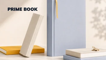 Prime Book — a hardback with a ribbon standing beside a flat book and a leaning cover